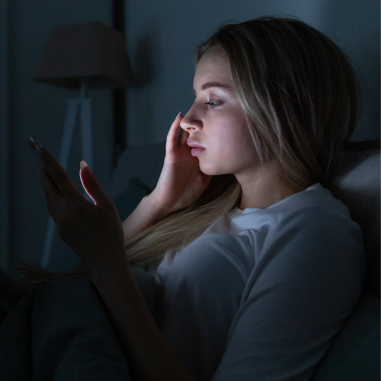 Woman Lying in Bed and Using Phone at Night