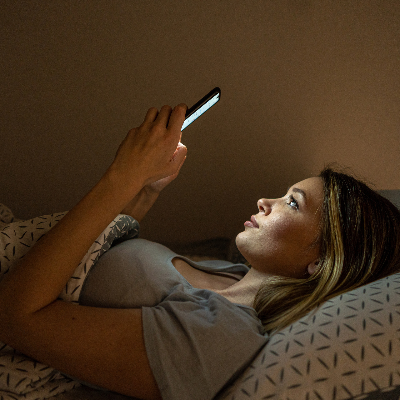Woman in bed using cellphone
