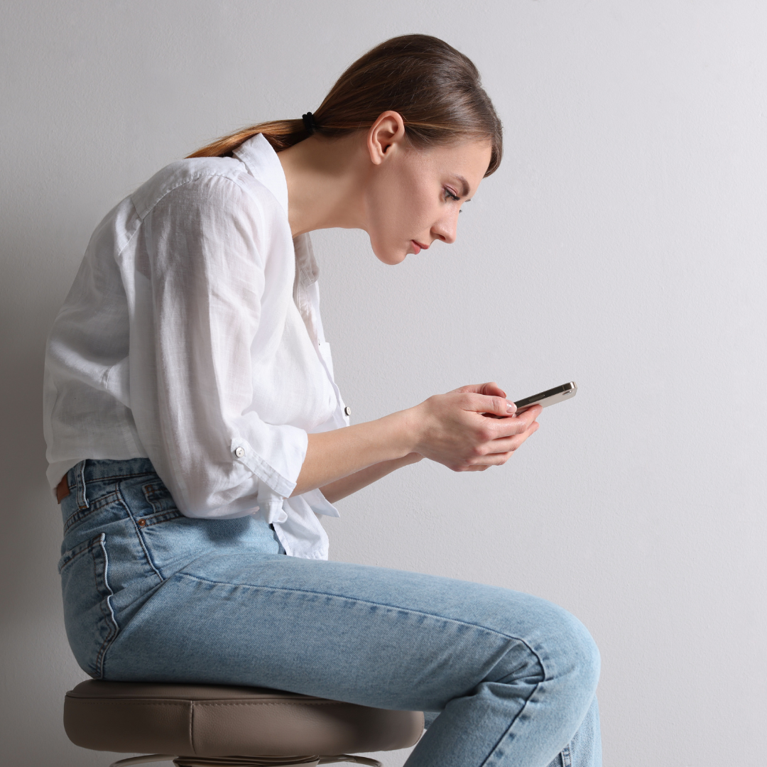 Woman with Bad Posture Using Smartphone While Sitting on Stool