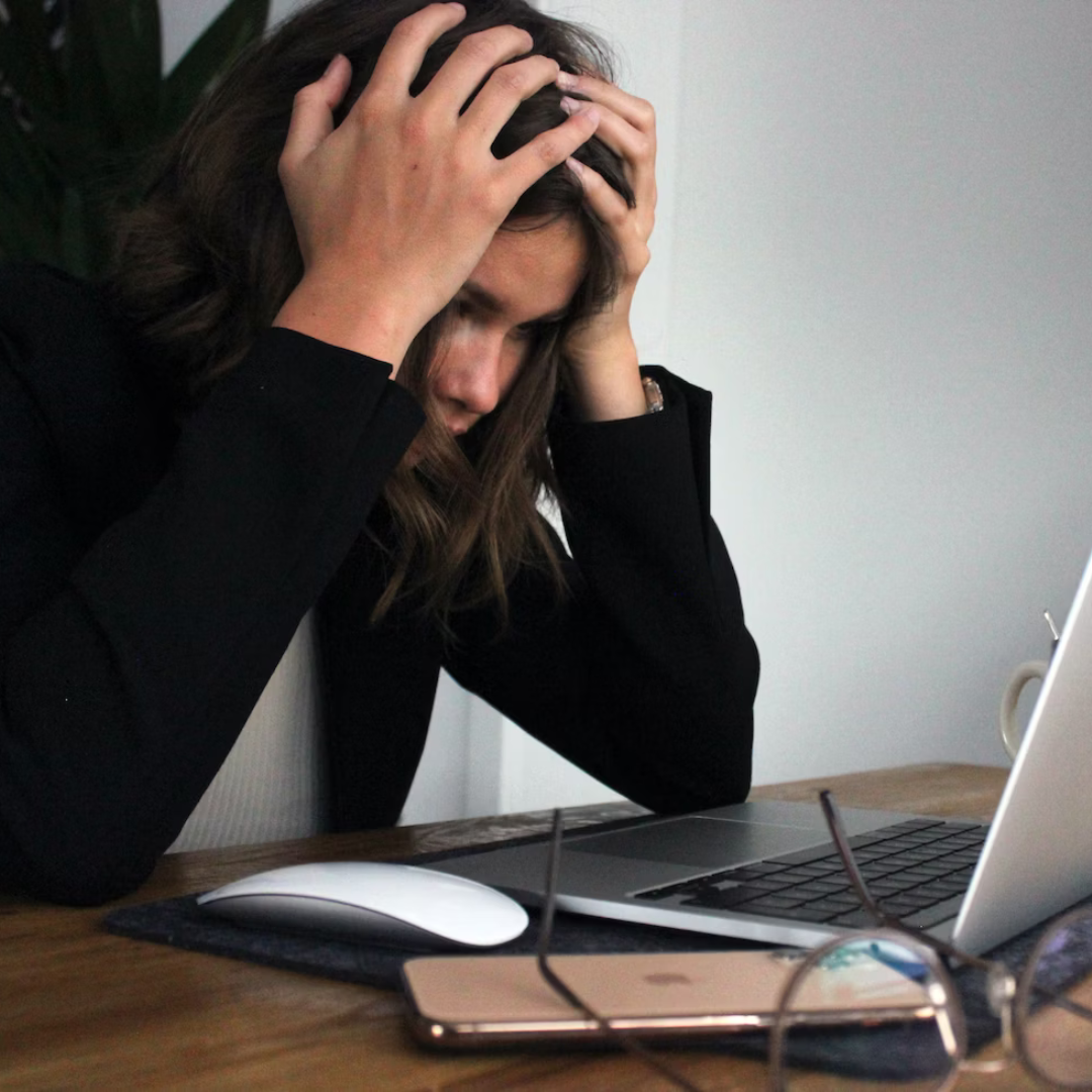 woman in black long sleeve shirt covering her face with her hands