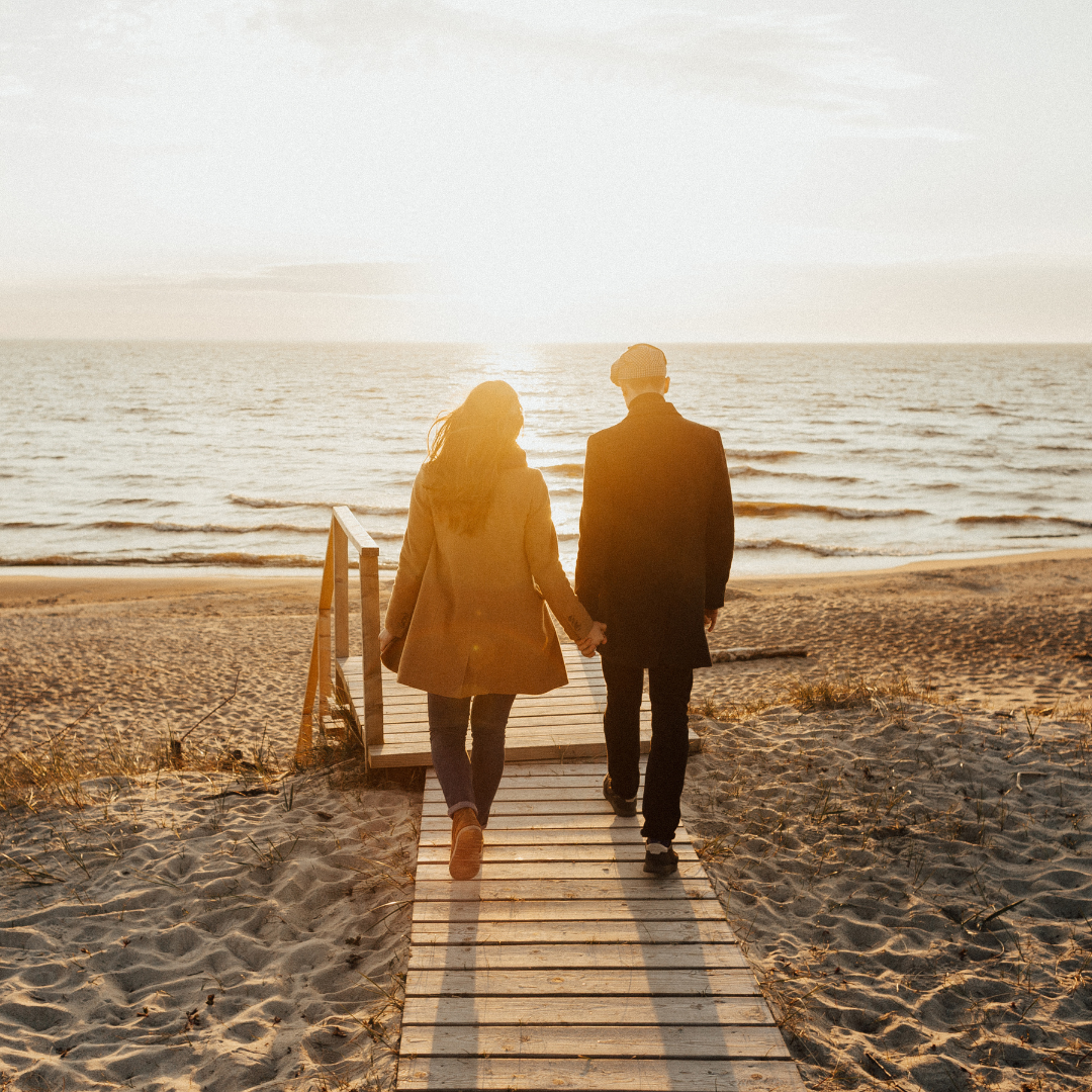 A Couple Walking on a Beach while Holding Hands