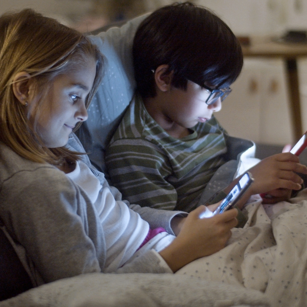 Kids Using Gadgets While on a Sofa Bed