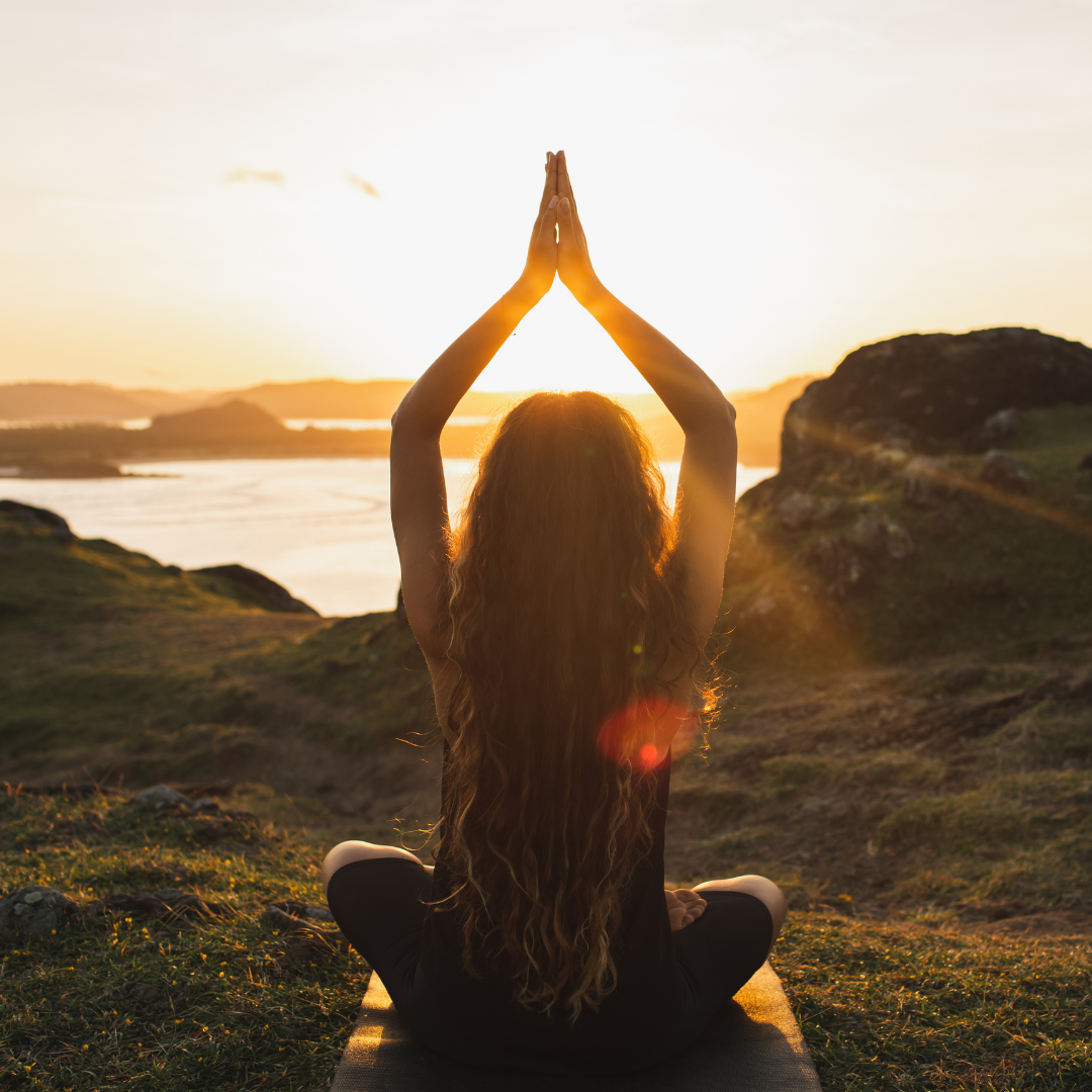 Young woman practicing yoga outdoors. Spiritual harmony, introspection and well-being concept.