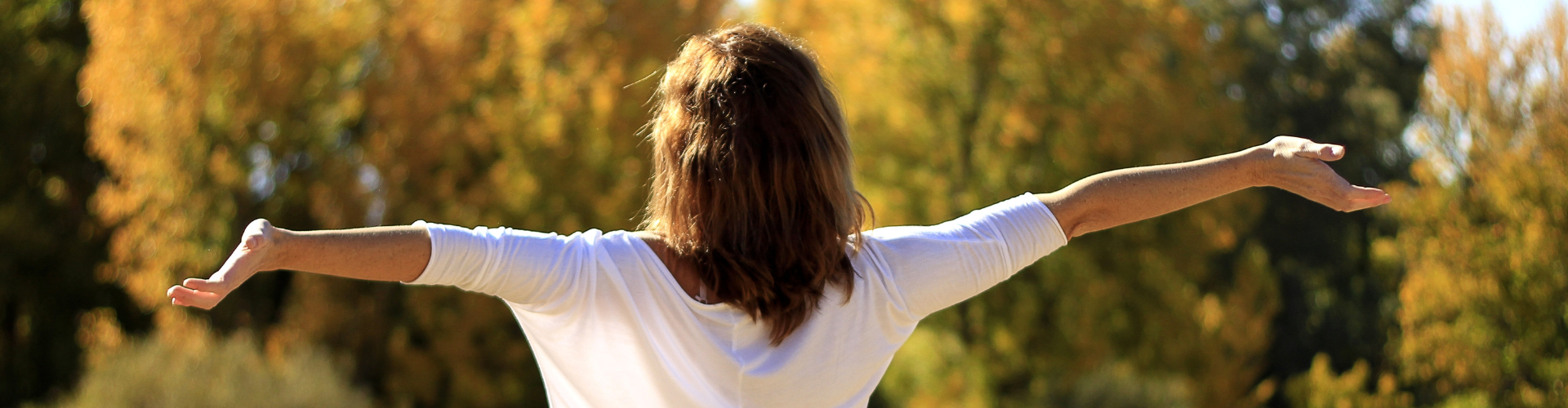 Woman in Wide Open Arms Facing the Sunlight