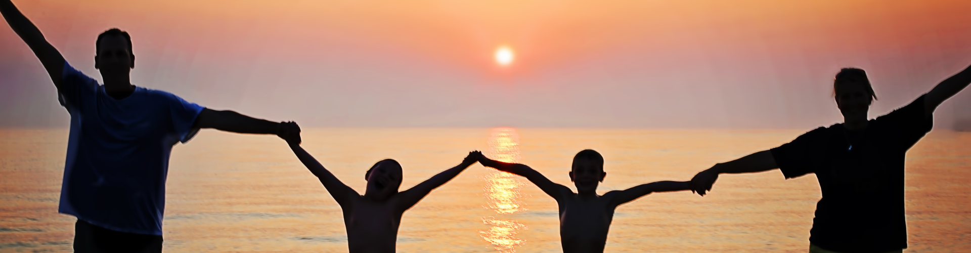 Silhouette of a Family by the Sea at Sunset