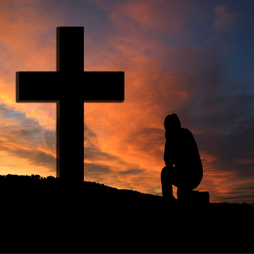 Man Kneeling in Front of a Cross