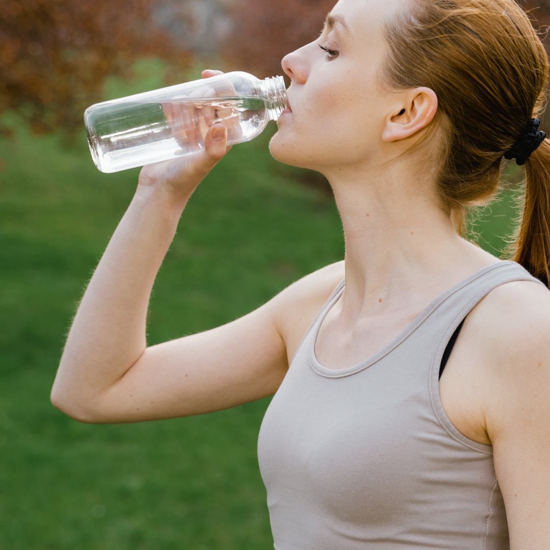 Woman in Activewear drinking a Bottle of Water