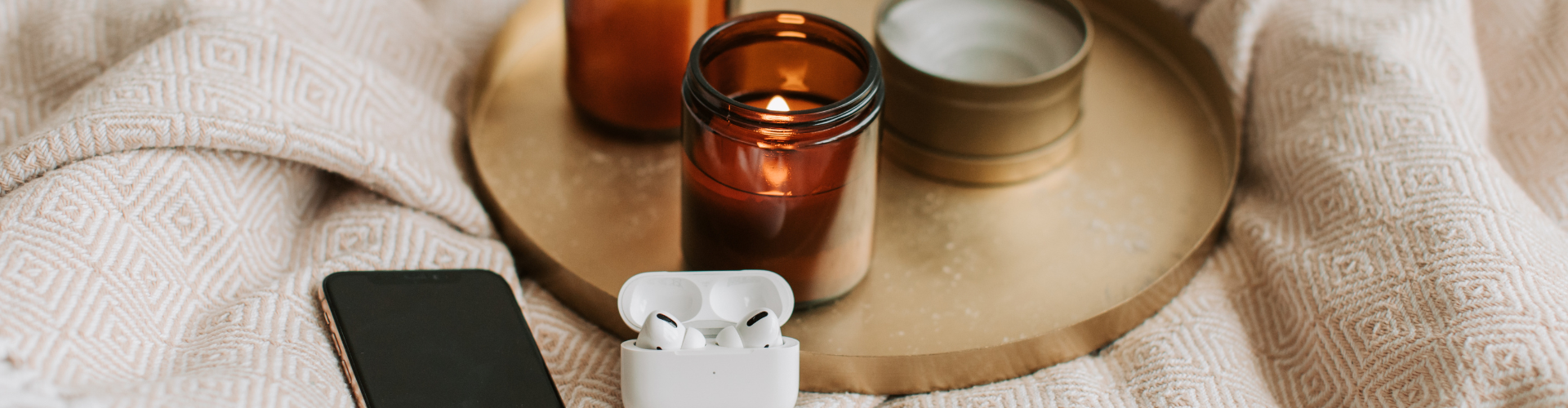 Gadgets and Scented Candles on Bronze Tray