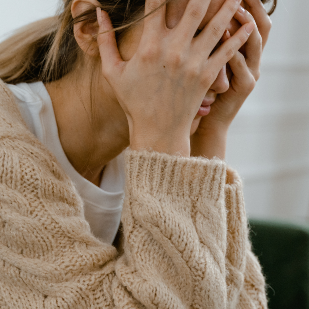 Woman Sitting with Hands Covering Her Face