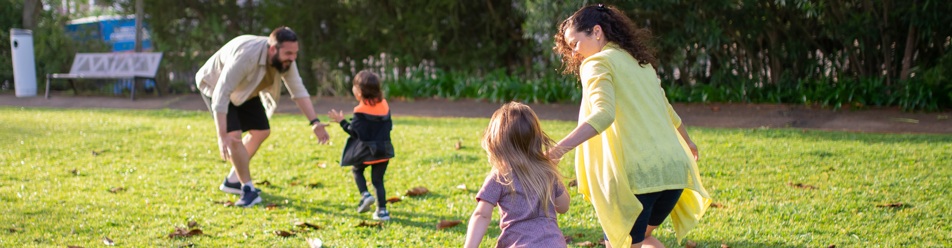 A Family Playing on the Green Grass Field