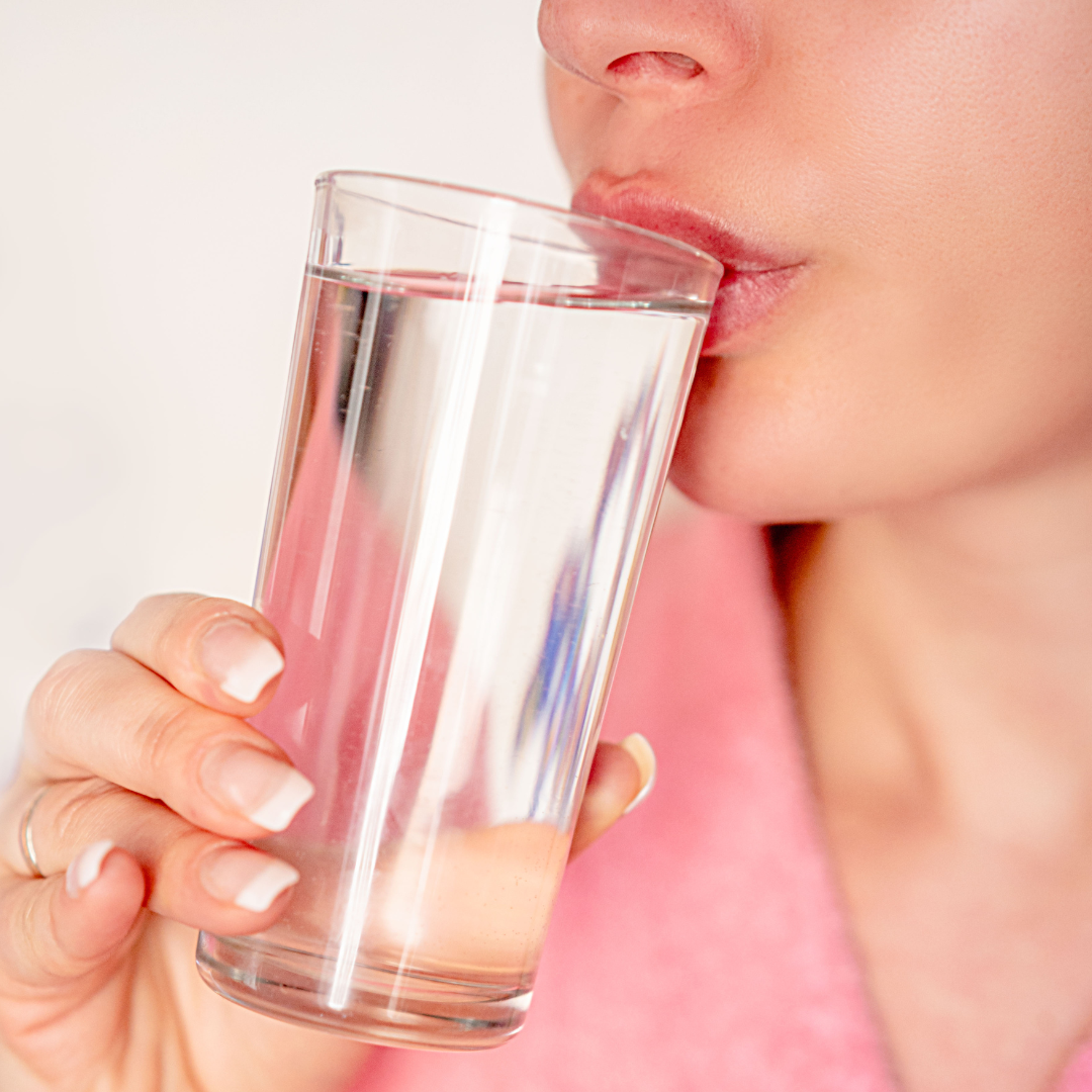 Woman drinking glass of water in morning