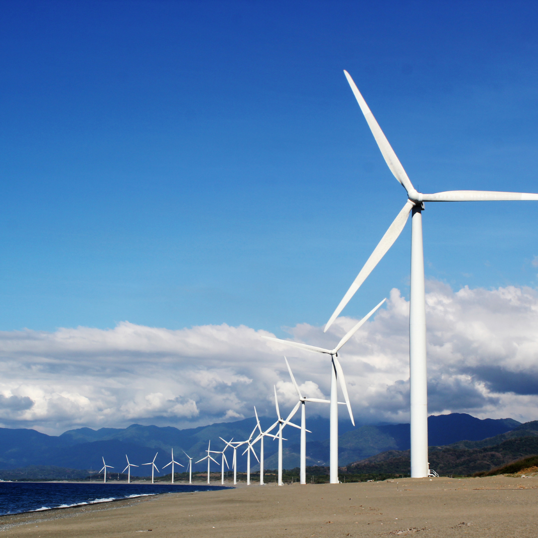 White Wind Turbines on Gray Sand Near Body of Water