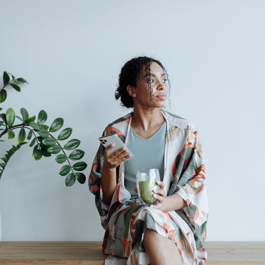 Photo of Woman Sitting Beside an Indoor Plant