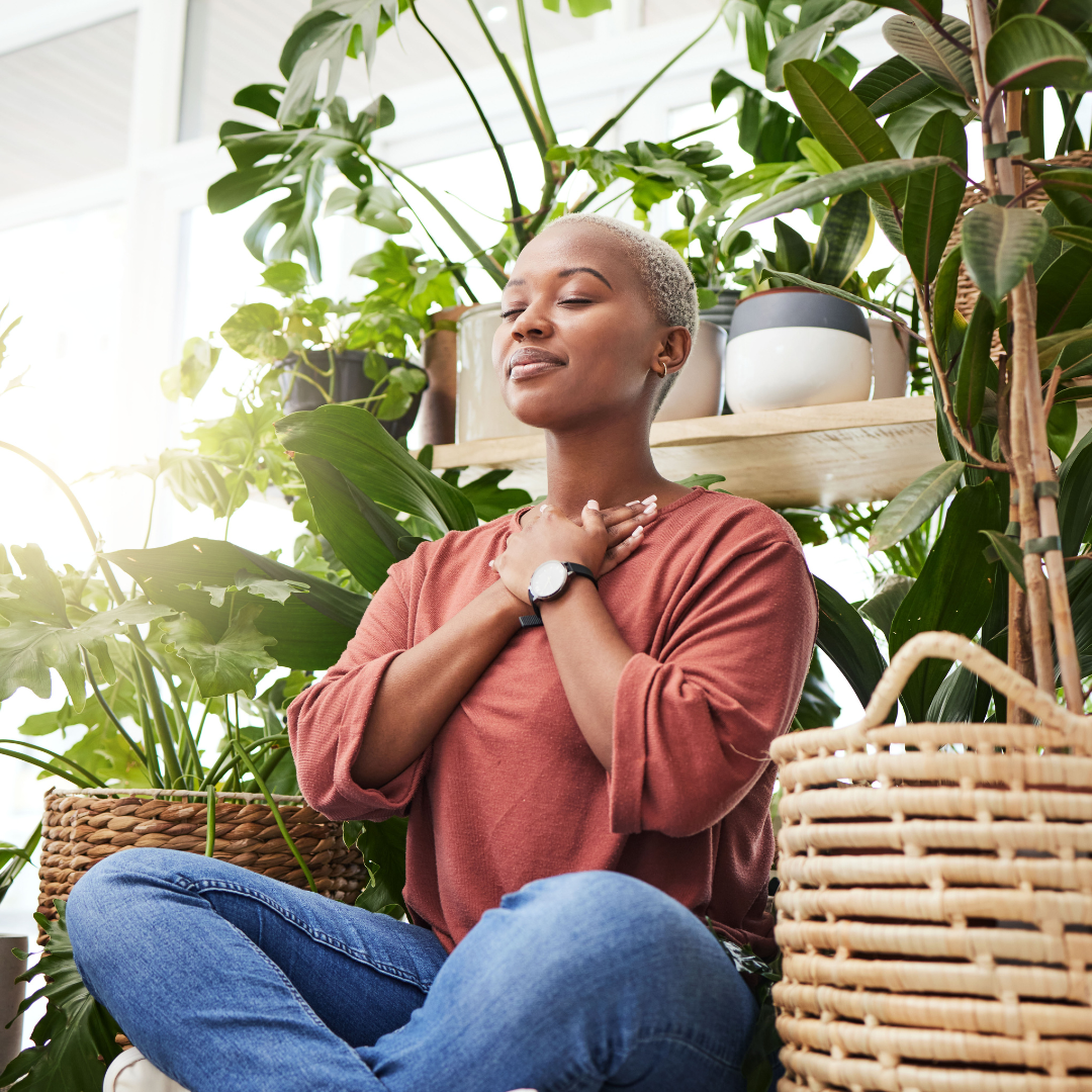 Wellness, Peace and Woman Breathing by Plants for Meditation in a Natural Greenhouse. Breathe, Gratitude and Young Calm African Female Person with a Relaxing Zen Mindset by an Indoor Nursery Garden.