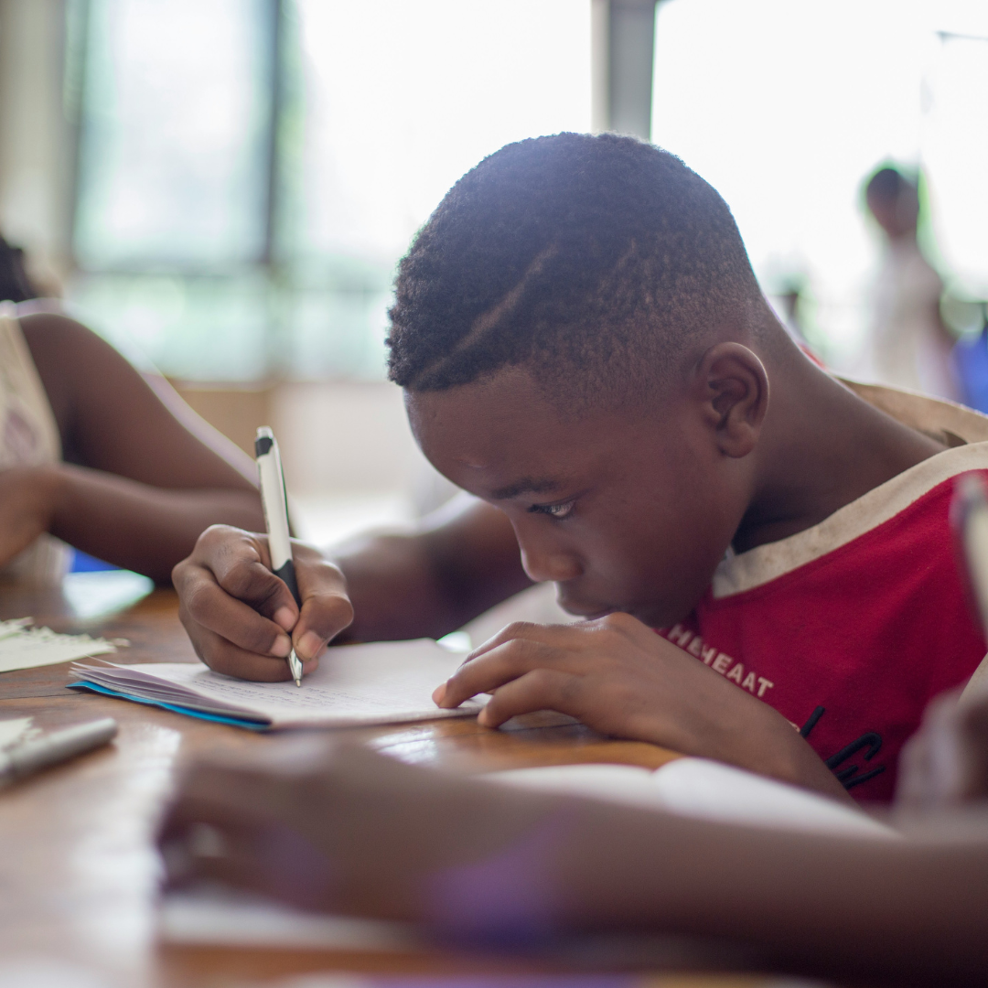 boy writing on printer paper near girl