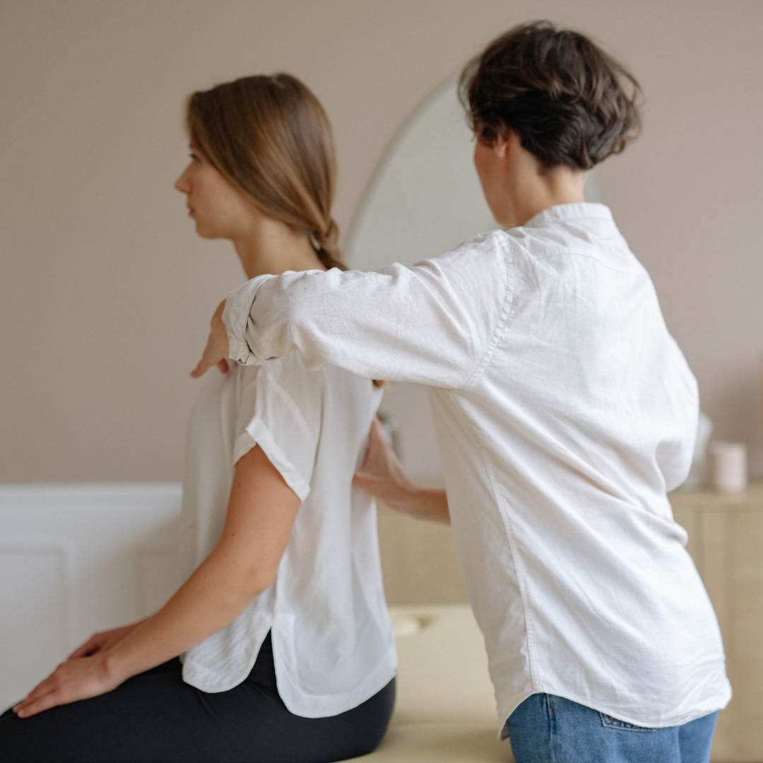 A Woman Sitting and Getting a Massage