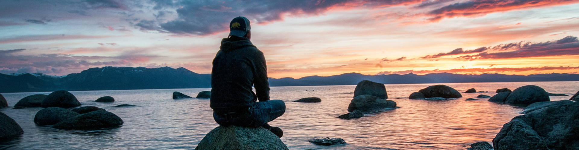 Man sitting on a stone by the ocean