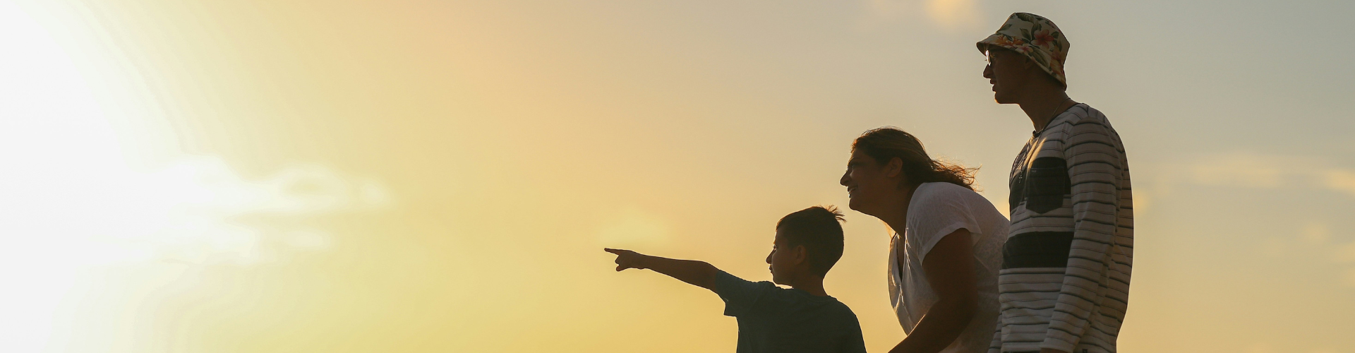 man and woman holding hands while walking on grass field during sunset