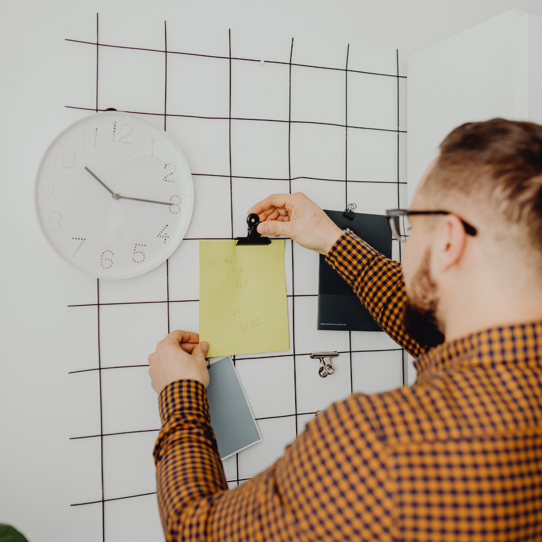 A Man Posting a Schedule Reminder