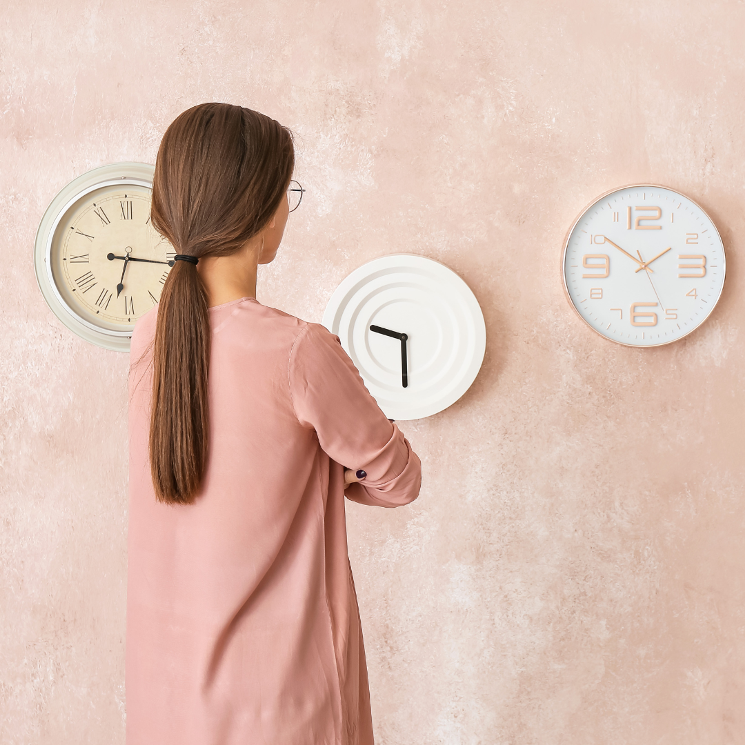 Young Woman Looking at Different Clocks
