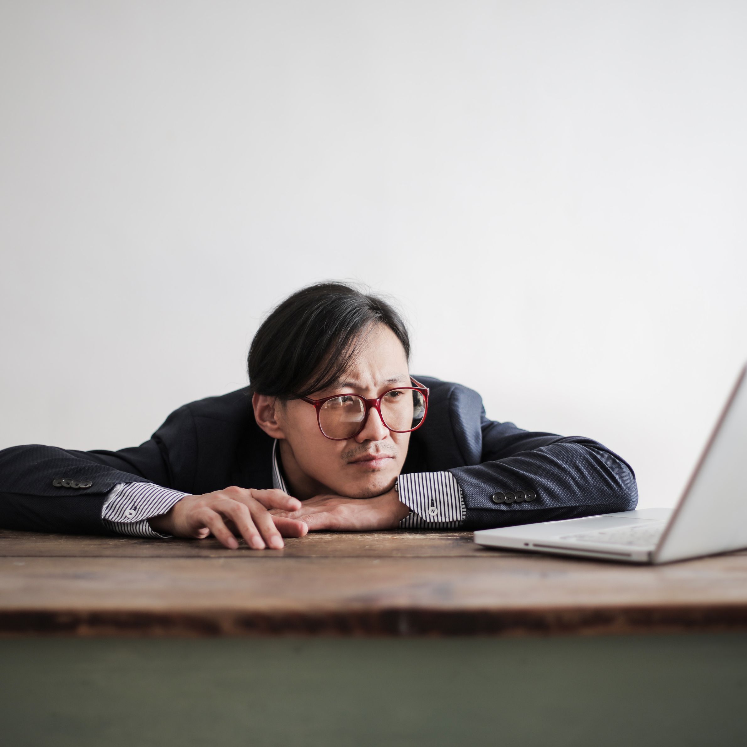 Bored formal man watching laptop at desk