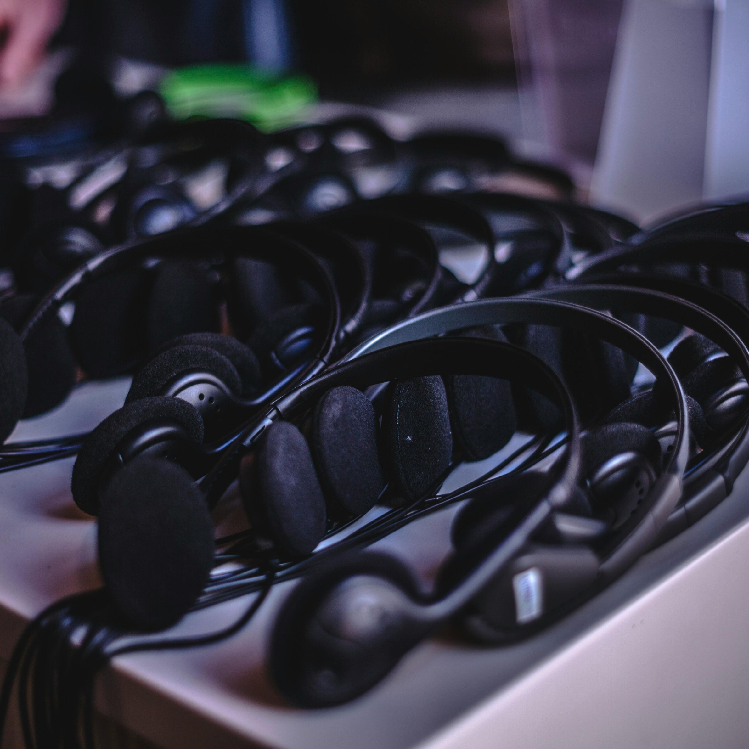 A variety of modern audio headsets neatly arranged on a display table indoors